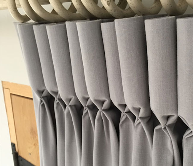 Goblet pleated drapes with wood curtain rings.